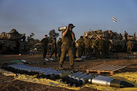 Israeli soldiers load shells onto a tank at a staging area in southern Israel near the border with Gaza (Photo | AP)
