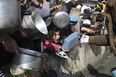 Palestinians, including children, line up for free food during the ongoing Israeli air and ground offensive on the Gaza Strip in Rafah, Tuesday, Jan 9, 2024. (Photo | AP)