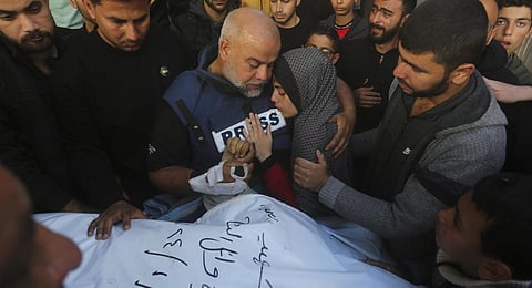 Al Jazeera journalist Wael Dahdouh holds the hand of his son Hamza, who also worked for Al Jazeera and who was killed in an Israeli airstrike in Rafah, Gaza Strip, Sunday, Jan. 7, 2024.(Photo | AP)