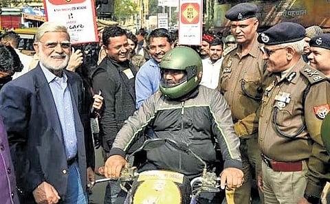 TNIE Editorial Director Prabhu Chawla and Varanasi police commissioner Mutha Ashok Jain distribute helmets at Chawka Ghat crossing | express