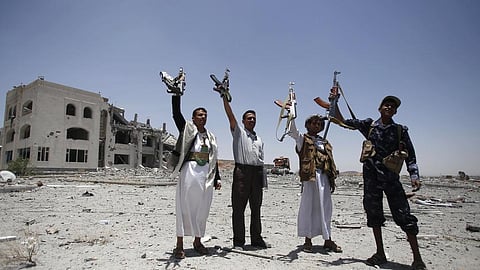 Houthi rebels hold up their weapons at the residence of a military commander of the Houthi militant group, in Sanaa, Yemen.