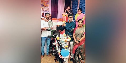 ​  Teacher Santosh Kanchan poses with the bike gifted to him by the residents of Valuru village in Sagar taluk | Express ​