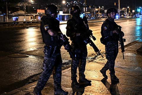 Members of a special sniper unit of the National Police stand guard while participating in a manhunt following the escape of several prisoners in Ecuador. (Photo | AFP)