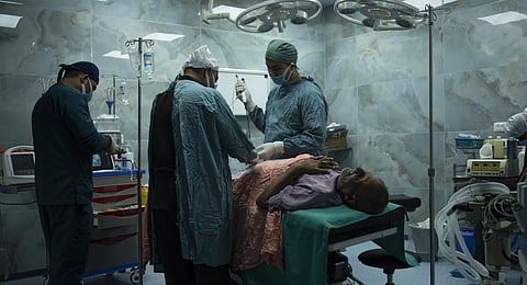 Dr. Suhaib Alhamss, the director of the Kuwaiti Hospital in Gaza's southern town of Rafah, performs surgery on a patient during his work day. (Photo | AP)