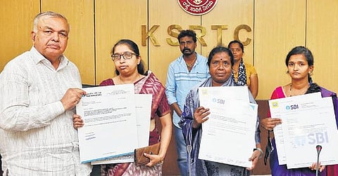 Transport Minister Ramalinga Reddy hands over cheques for Rs 1 crore each to  the families of KSRTC employees, at the KSRTC head office on Monday