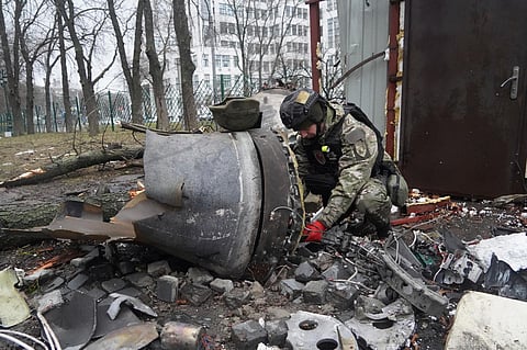A Ukrainian police officer inspects a rocket part near a residential building damaged by a Russian missile strike in Kharkiv, Ukraine. (Photo| AP)