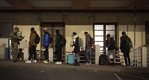 Migrants line up to be checked by authorities (Photo | AP)