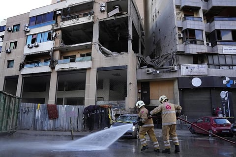 Civil defense workers clean the street in front of an apartment building where an apparent Israeli strike Tuesday killed top Hamas political leader Saleh Arouri (Photo |AP)