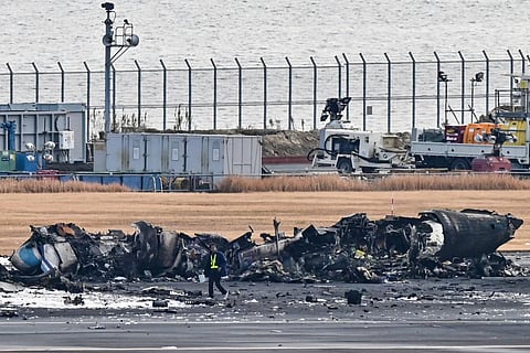 An official looks at the wreckage of a Japan coast guard plane on the tarmac at Tokyo International Airport at Haneda in Tokyo on January 3, 2024. (Photo | AFP)