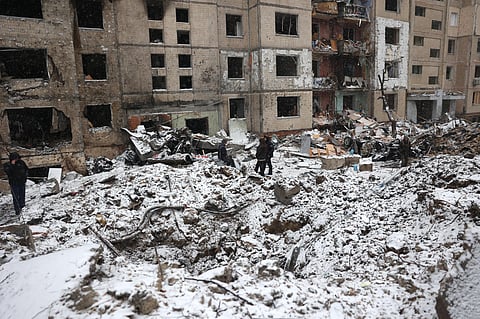 Police officers and local residents inspect damage outside a destroyed high-rise building following a Russian missile attack in central Kyiv. (Photo | AFP)