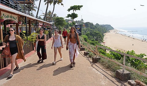 Foreign tourists walk through the pathway atop the Papanasam Cliff at Varkala. (Photo | B P Deepu)