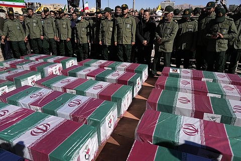 Revolutionary Guard members stand over the flag-draped coffins of victims of Wednesday's bomb explosion during their funeral ceremony in the city of Kerman. (Photo | AP)