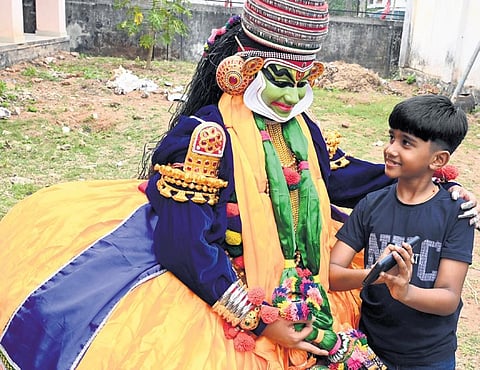Shriya Sanjith, a kathakali participant from Carmel School at Vazhuthakad, watching the video of her performance that was shot by her brother on Saturday
