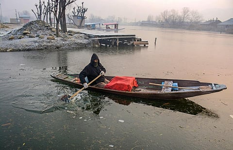 A boatman rows through partially frozen Dal Lake, in Srinagar. The 40-day harshest winter period in Kashmir, known as 'Chillai Kalan', began from December 21. (Photo | PTI)