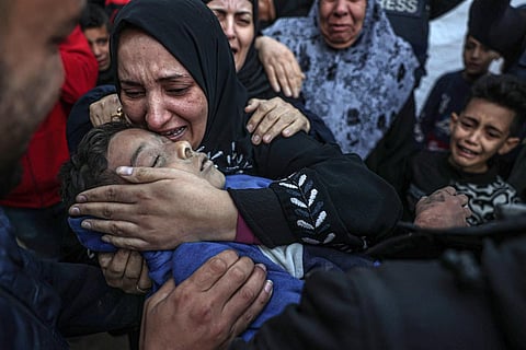 The aunt of a 12-year-old, who was killed along with his family during Israeli bombardment, mourns as she holds his body at the European hospital in Khan Yunis, on Jan 6, 2024. (Photo | AFP)