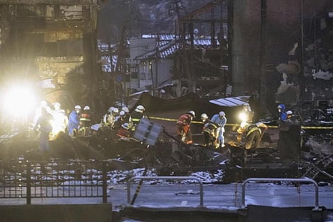 Firefighters search the rubble of fallen buildings near a marketplace in Wajima, Ishikawa. (Photo | AP)