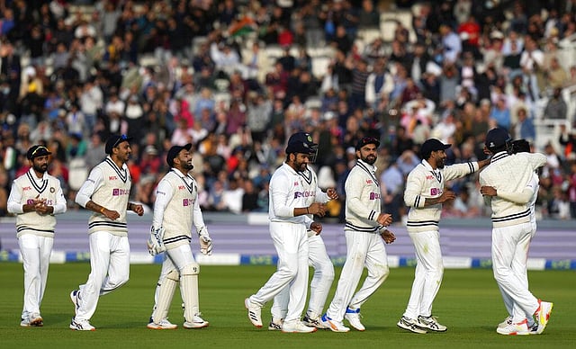 Members of the Indian cricket team line up to congratulate India's Mdohammed Siraj, at right after he took the wicket of England's Jos Buttler. (Photo | AP)