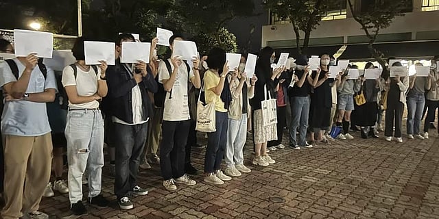 Protesters hold up blank white papers during a commemoration for victims of a recent Urumqi deadly fire at the Chinese University of Hong Kong in Hong Kong. (Photo | AP)