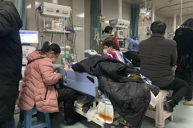 Relatives gather near the beds of sick patients at the emergency department of the Langfang No. 4 People's Hospital in Bazhou city in China. (AP)