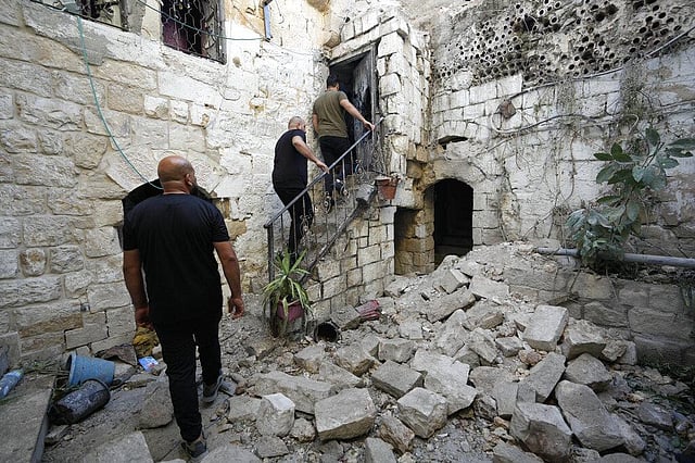 Palestinians inspect the damage to a house. (Photo | AP)