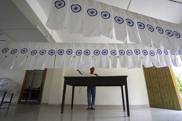 A man works on an under-production Indian national flag to dry in an office ahead of Independence Day. (File Photo | AP)