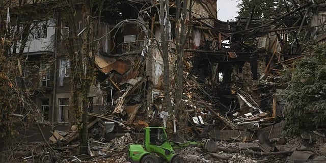 Communal workers clean the debris from the street in front of a heavily damaged building after a Russian attack in Sloviansk, Ukraine. (Photo | AP)