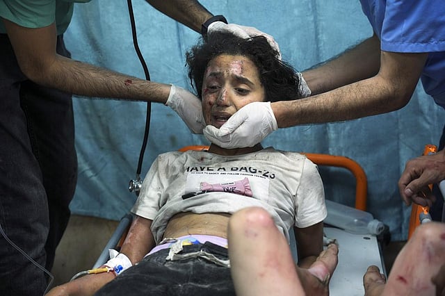 A Palestinian child wounded in Israeli bombardment is treated in a hospital in Deir al-Balah, southern Gaza Strip | AP