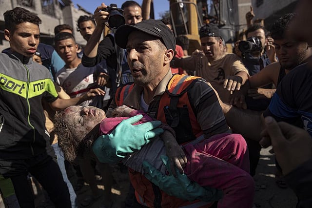 Palestinians evacuate a child after an Israeli airstrike on Khan Younis, Gaza Strip, Tuesday, Oct. 17, 2023 | AP