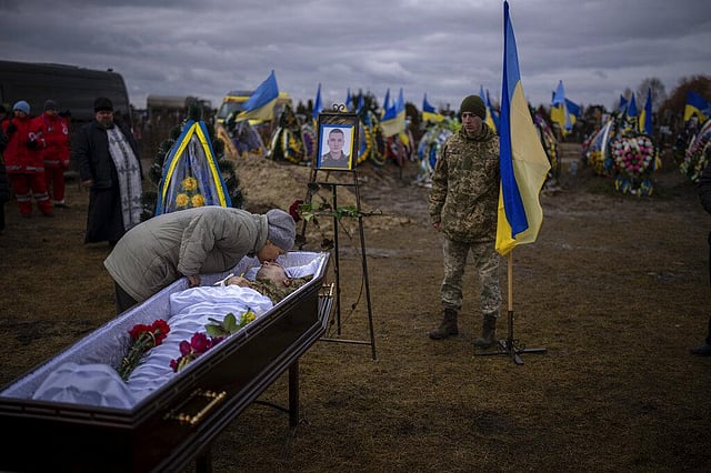 The family member of a Ukrainian civilian Oleksii Lytvynov embraces him at his funeral in Brovary, near Kyiv, Ukraine, Sunday, Feb. 19, 2023. Lytvynov had joined the Ukrainian Armed Forces to defend Kyiv and was killed on Feb. 11. (Photo | AP)
