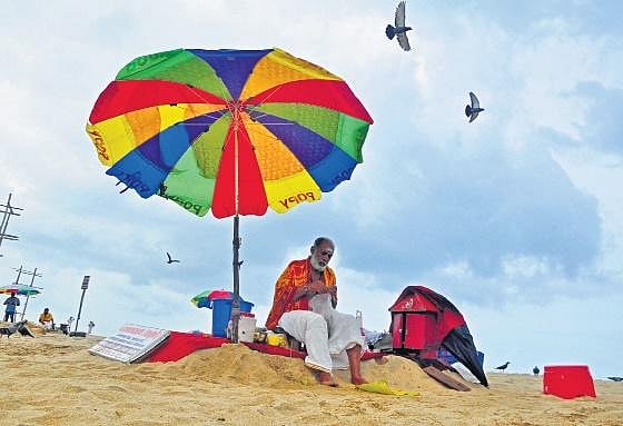 File pic of a priest on the Papanasam beach at Varkala in Thiruvananthapuram 