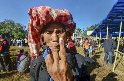 An elderly Bru tribal woman shows her finger marked with indelible ink as she comes out of a polling station after casting vote for the Mizoram Assembly elections at Kanhmun. (Photo | PTI)