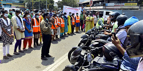 Corporation workers creating awareness during the signal red light to motorists. (Photo | EPS / D Sampath)
