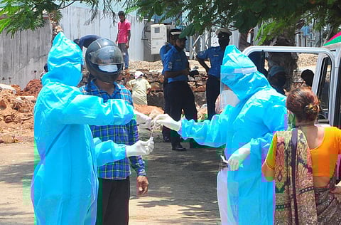 Health workers cutting the end of a swab instead of breaking it by hand after collecting the swab samples in Visakhapatnam on Wednesday. (Photo | EPS/G satyanarayana)