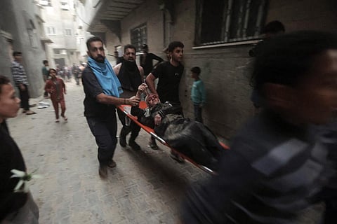 Palestinians evacuate a wounded woman following an Israeli airstrike in Khan Younis refugee camp, southern Gaza Strip. (Photo | AP)