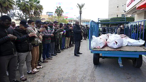 Palestinians pray for the relatives killed in the Israeli air and ground offensive on the Gaza Strip at a hospital in Deir al Balah 