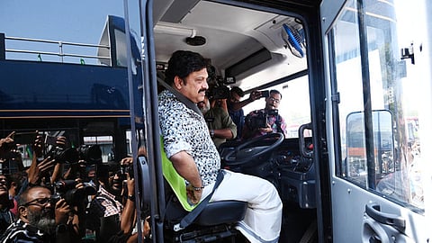 Transport Minister KB Ganesh Kumar poses for a photograph before test-driving the new electric double decker bus.
