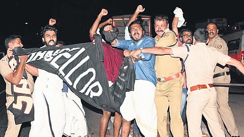Police personnel prevent SFI activists from showing a black banner to Governor Arif Mohammed Khan on Container Road while he was on his way to the Coast Guard guest house in Fort Kochi from Kochi airport on Tuesday