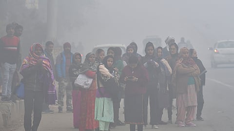 Commuters out on cold and foggy morning in New Delhi.
