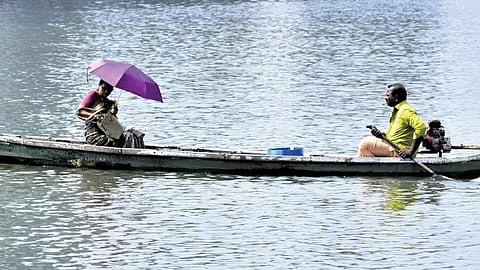 A woman takes a country boat to cross the backwater at Thanthonnithuruthu in Kochi under the scorching sun | A Sanesh