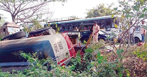 A cop is seen next to the overturned fuel tanker at Neerukulla crossroads on NH-163