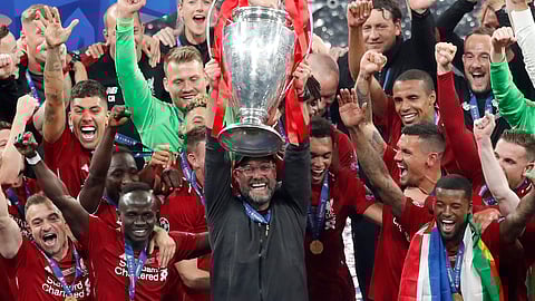 Liverpool coach Juergen Klopp lifts up the trophy as he celebrates with players after winning the Champions League final soccer match between Tottenham Hotspur and Liverpool at the Wanda Metropolitano Stadium in Madrid.