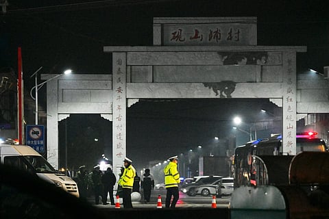 Police stand guard after a school was engulfed by fire in Yanshanpu in China’s Henan province on January 20, 2024.