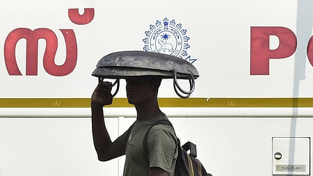 A migrant worker is using his iron tesla to escape from the heat of the scorching sun in Kochi on Sunday. 