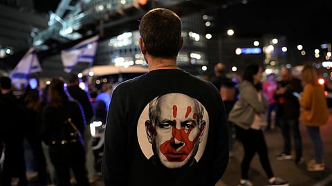 A protester wears a shirt depicting Israeli Prime Minister Benjamin Netanyahu during a demonstration to demand the release of the hostages taken by Hamas militants into the Gaza Strip during the Oct. 7th attack, in Tel Aviv, Israel, Saturday Jan. 20, 2024.