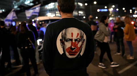A protester wears a shirt depicting Israeli Prime Minister Benjamin Netanyahu during a demonstration to demand the release of the hostages taken by Hamas militants into the Gaza Strip during the Oct. 7th attack, in Tel Aviv, Israel, Saturday Jan. 20, 2024.
