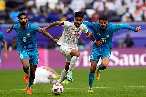 Syria's Mahmood Alaswad, center, fights for the ball against India's Akash Mishra, left, and India's Deepak Tangri during their Asian Cup match