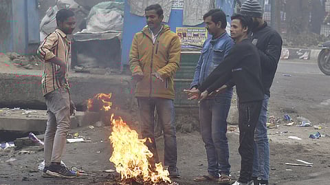 People around a bonfire to protect themselves from winter on a coldest and foggy morning in New Delhi, 