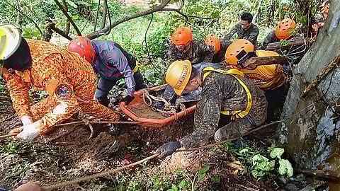 Rescuers retrieve a body of one of the victims after a landslide due to heavy rains at Monkayo town in Davao de Oro province, southern Philippines