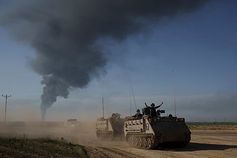 Israeli soldiers move on armored personnel carriers (APC) near the Israeli-Gaza border