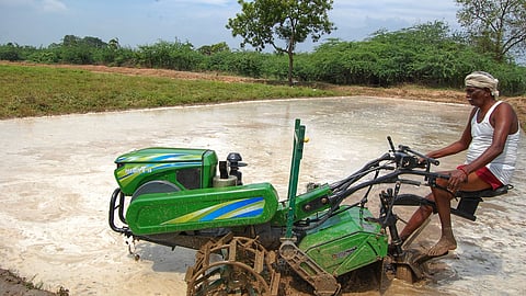 A farmer ploughs an agricultural land for planting crops.